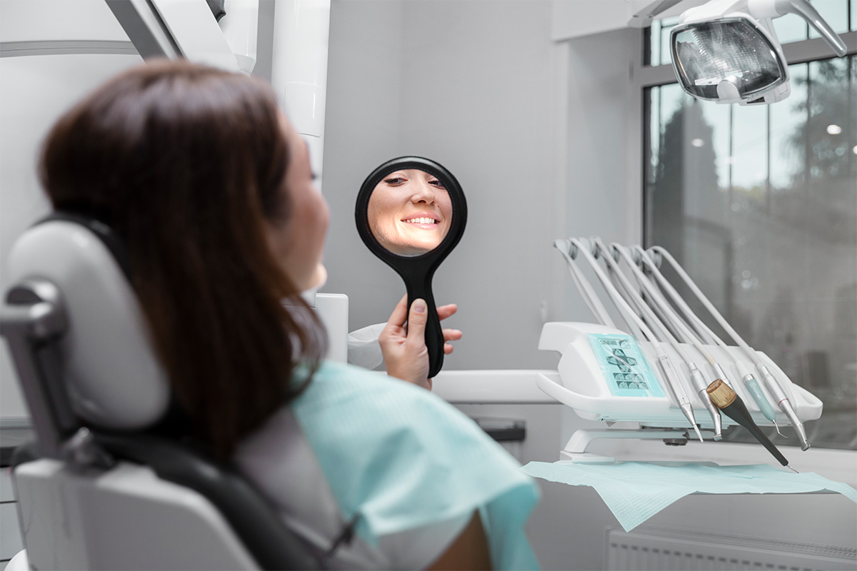 cerrar-paciente-mirando-en-el-espejo Cosmodent Candelaria - Clínica Dental en Tenerife | Reconstrucción con poste dental: qué es, para qué sirve y cuándo se recomienda